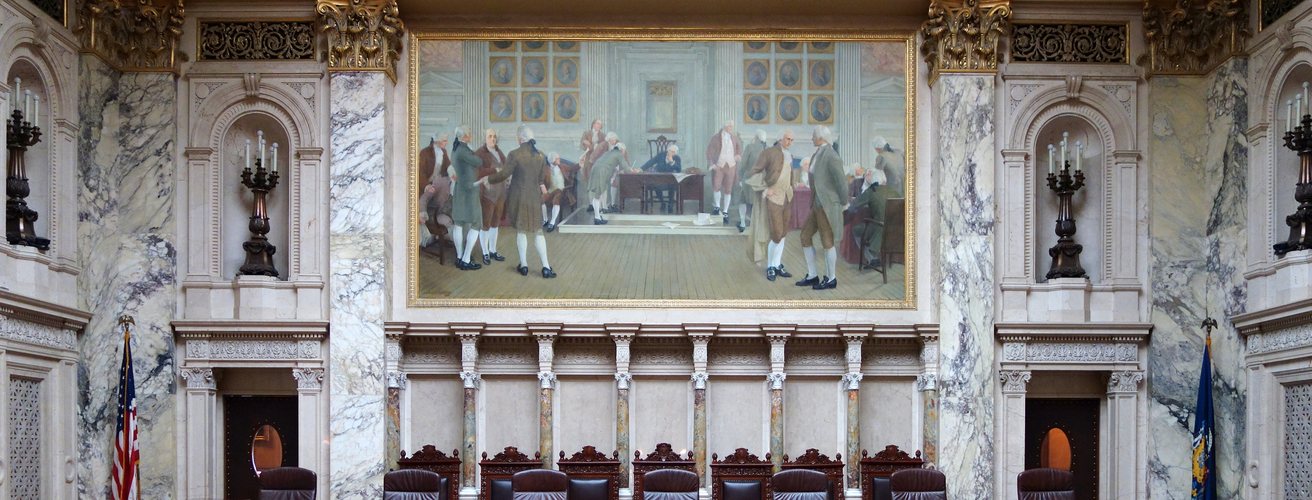 Marble walls and a mural above the bench of a supreme court